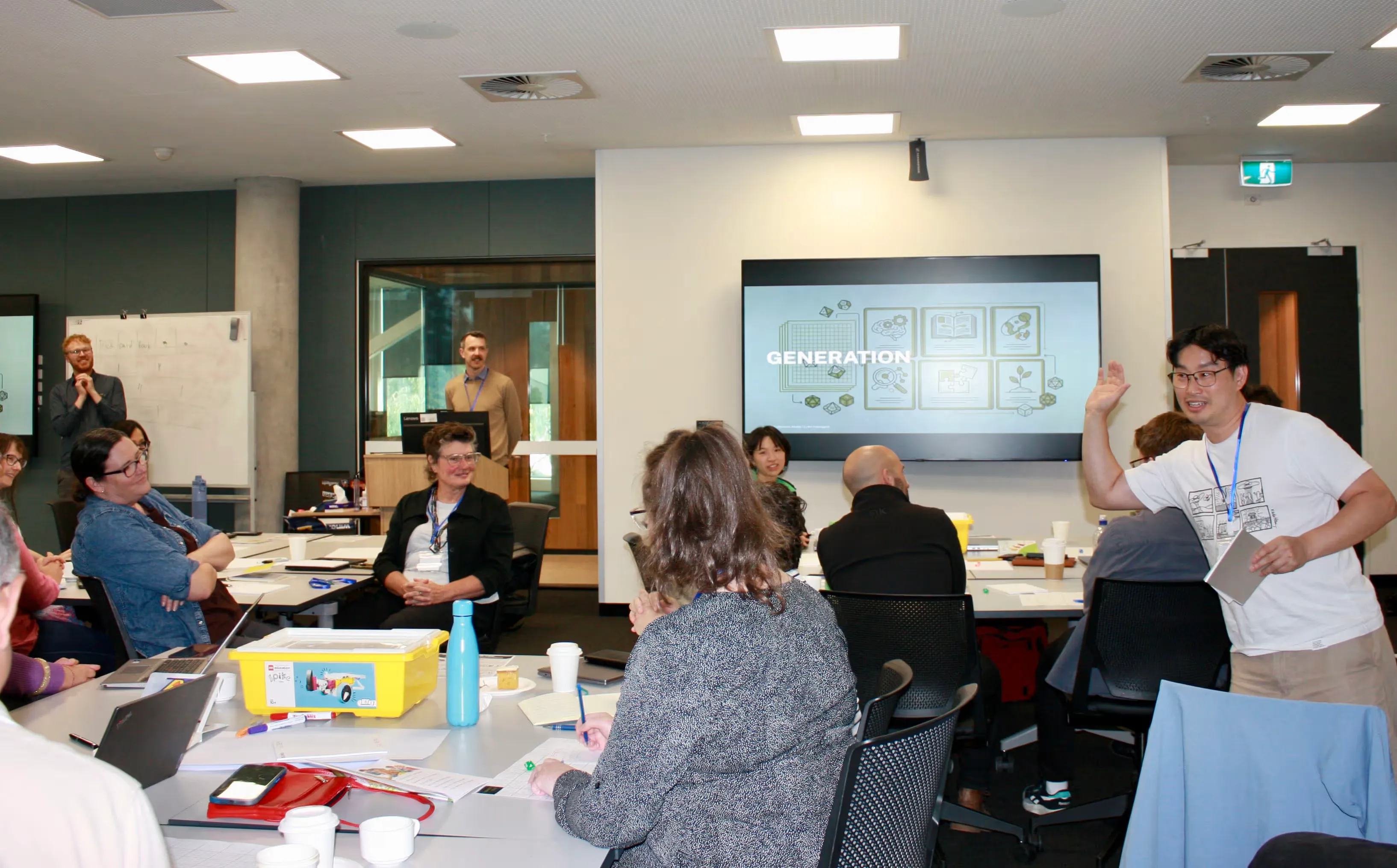 Participants in the workshop, with a "Generation" slide on screen and one attendee raising their hand