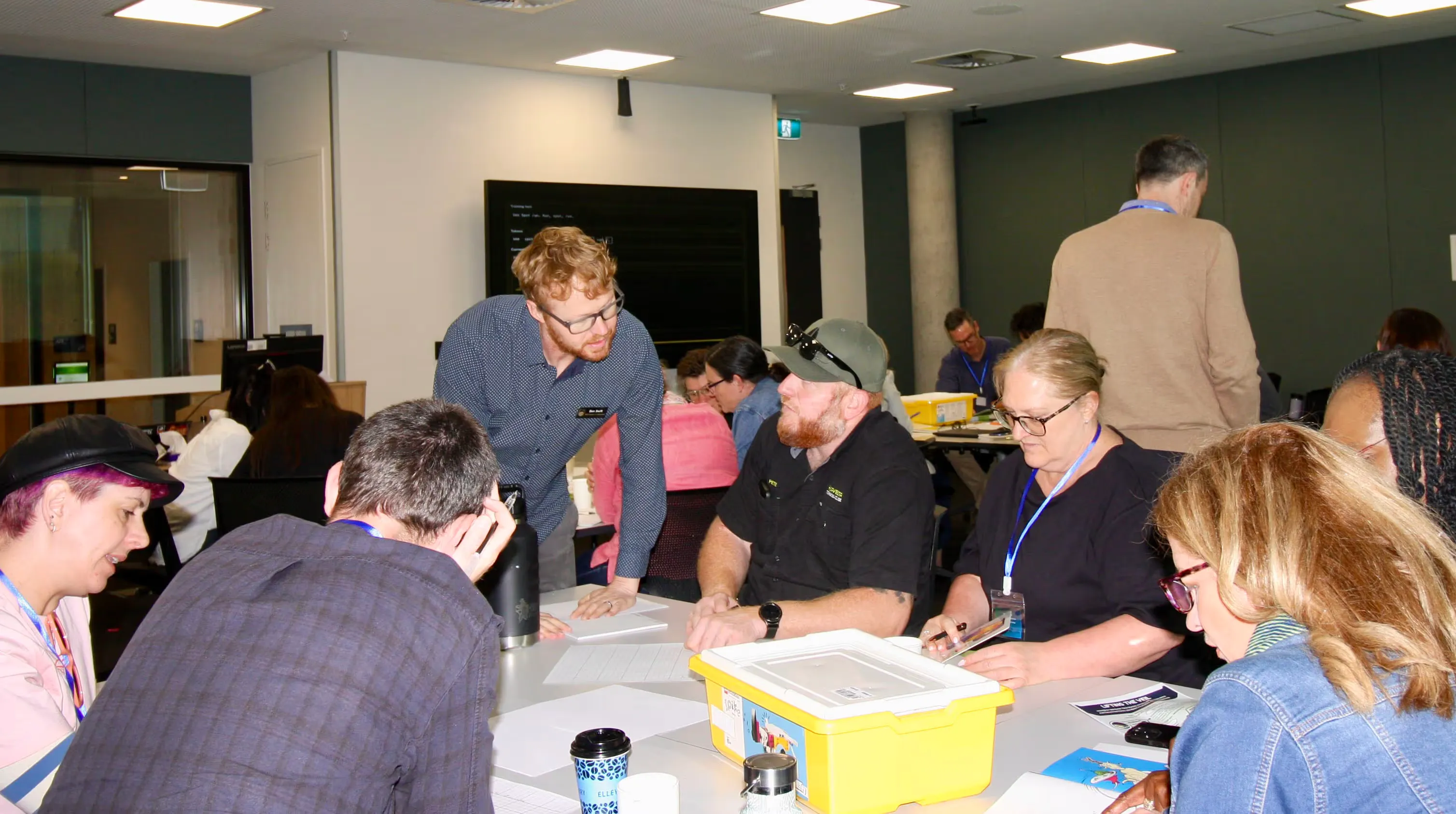 A facilitator helping participants at their table as they work through the activity together
