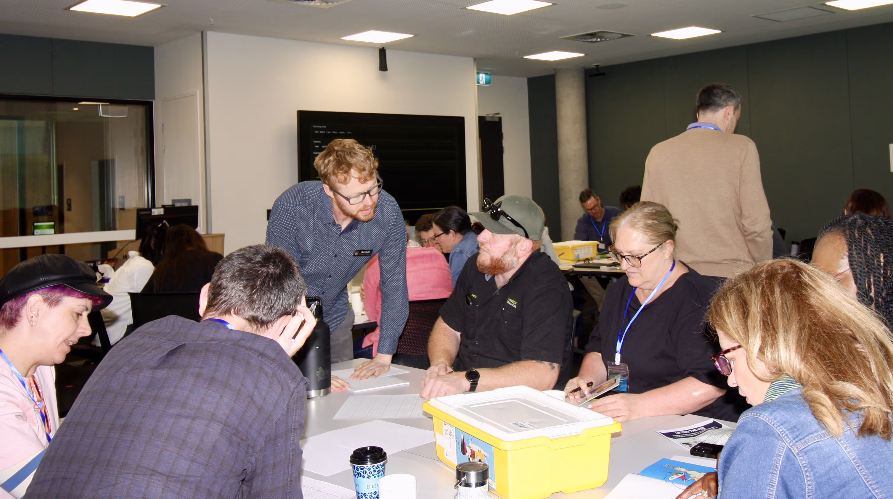 A facilitator helping participants at their table as they work through the activity together