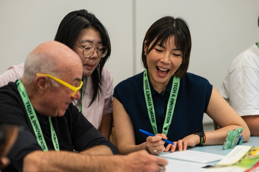 Three people laughing while doing an LLMs Unplugged activity